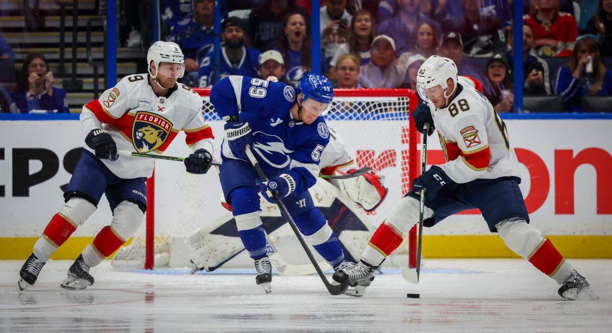 Tampa Bay Lightning center Jake Guentzel (59), center, along with Florida Panthers center Sam Bennett (9), left, and Florida Panthers defenseman Nate Schmidt (88) look to contain the puck during the second period in Game 1 in the first round of the Stanley Cup Playoffs Tuesday, April 22, 2025 in Tampa.