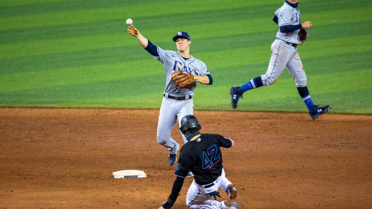Tampa Bay Rays second baseman Joey Wendle (42) throws to first base to get Marlins infielder Brian Anderson (42) out at second and complete the double-play during the sixth inning of a Major League Baseball game against the Miami Marlins at Marlins Park in Miami, Florida on Sunday, August 30, 2020.