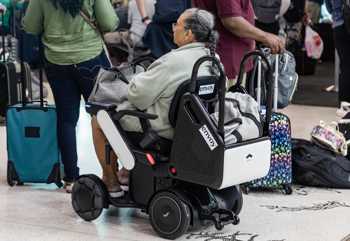 American Airlines customer rides on a WHILL autonomous wheelchair before her flight in Concourse D at Miami International Airport on Friday, June 21, 2024 in Miami, Fla.