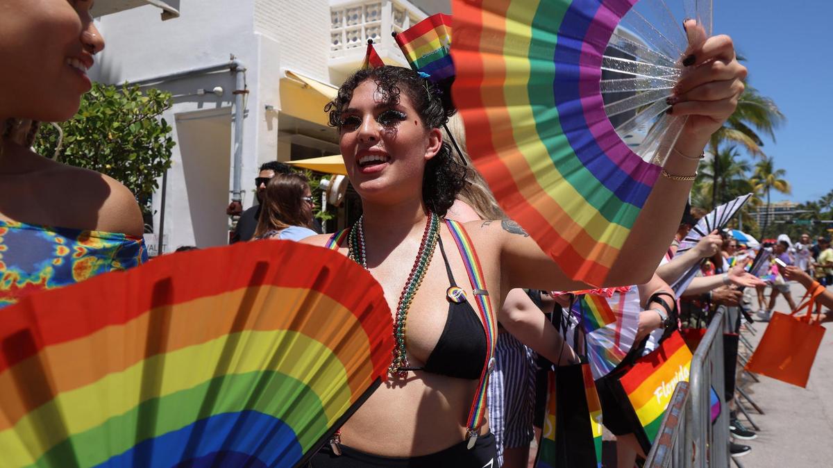 Dominque Mosely, 22, left, and friend Kyara Nall, 22, keep cool with rainbow fans on April 16, 2023, on Ocean Drive during the Pride parade.