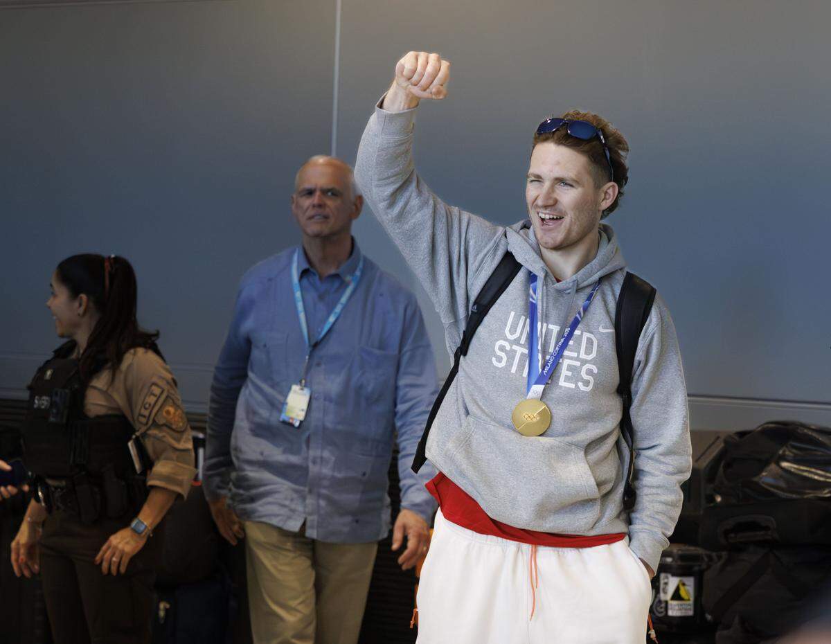 Matthew Tkachuk raises a fist in the air as Team USA's men's hockey team arrives at Miami International Airport on Monday, Feb. 23, 2026, in Miami after flying from Milan following their gold medal victory over Canada yesterday at the 2026 Winter Olympics in Milano Cortina, Italy.