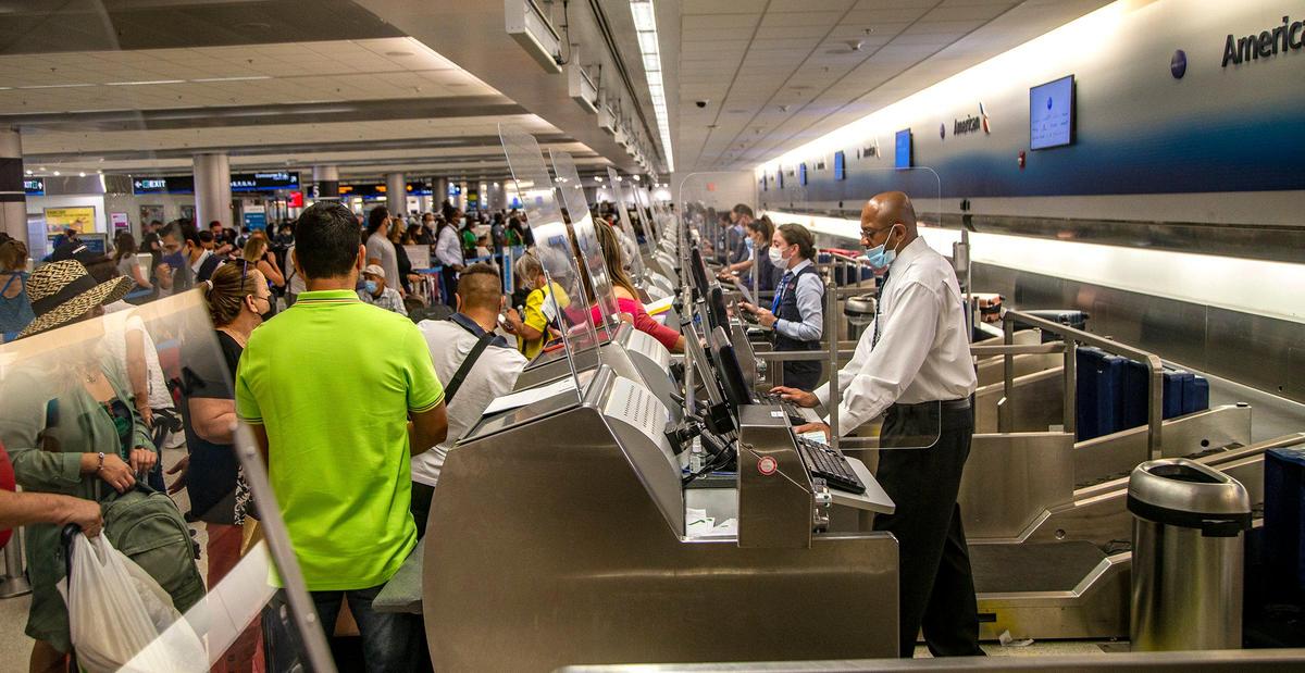 Travelers flooded American Airlines counters early morning Friday as travelers at Miami International Airport and other airports across the country experienced delays after a technical issue made it difficult for people to book tickets and check in for flights from several carriers, on Friday, May 21, 2021.