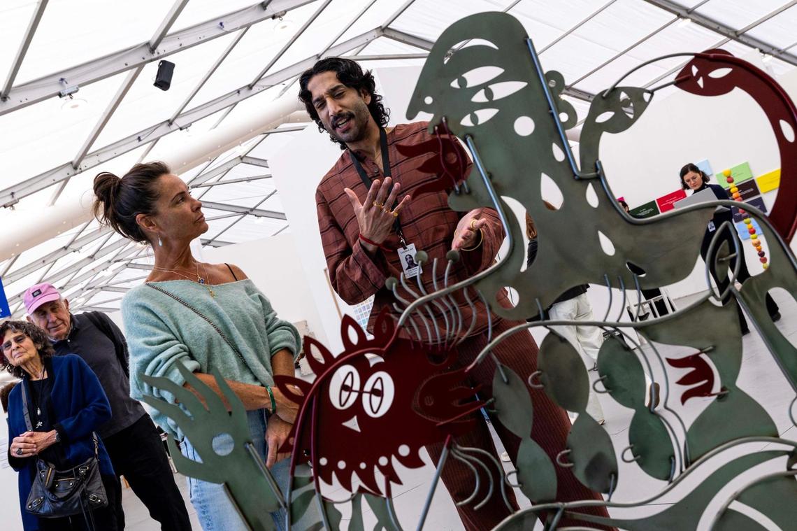 Art director Rajiv Menon speaks with guest Jane Read about a sculpture by artist Tarinisethi at Untitled Art Fair for Art Week on Tuesday, Dec. 3, 2024, in Miami Beach, Fla