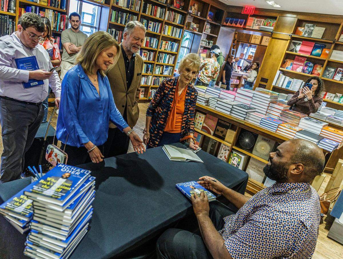 El escritor Michael Oher charla con June y Allen Morris, de izquierda a derecha, y Dorothy Thomson, la primera alcaldesa de Coral Gables, mientras firma autógrafos en su libro titulado 'When Your Back's Against the Wall: Fame, Football, and Lessons Learned through a Lifetime of Adversity' en Books &amp; Books, en Coral Gables, el miércoles 23 de agosto de 2023.
