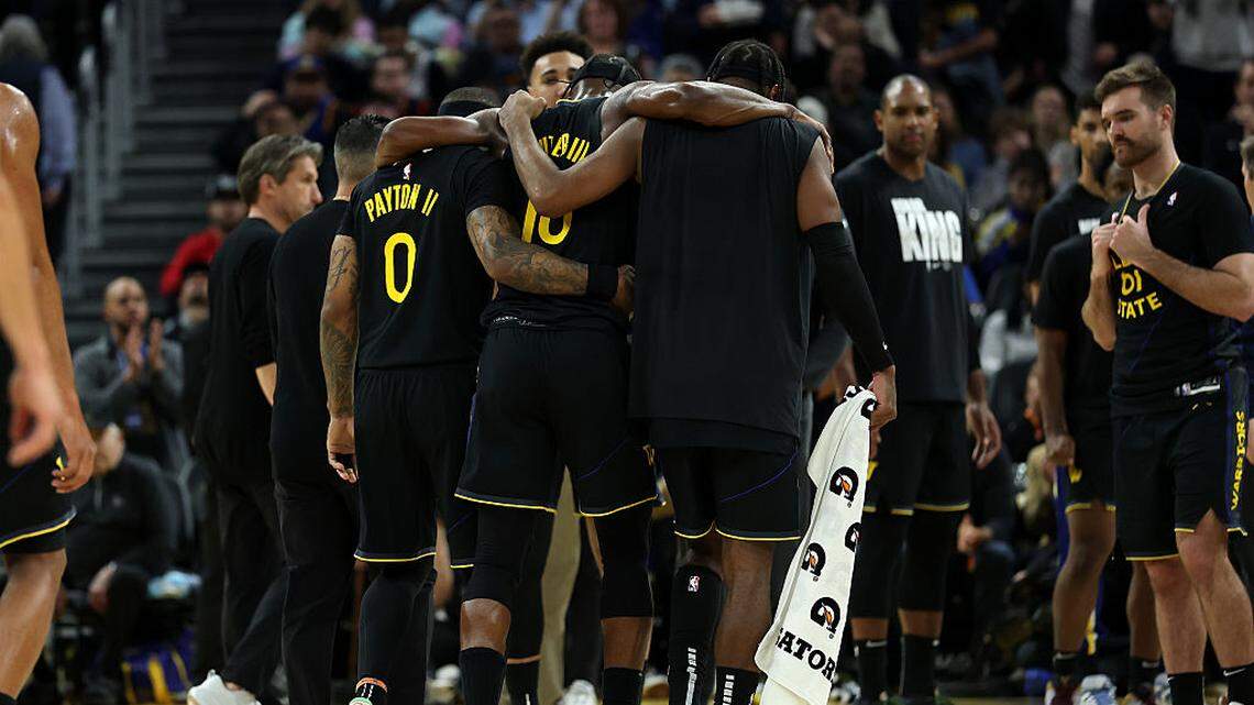 Jimmy Butler III #10 of the Golden State Warriors is helped off the court after he collided with Davion Mitchell #45 of the Miami Heat and injured his knee during the third quarter at Chase Center on January 19, 2026 in San Francisco.
