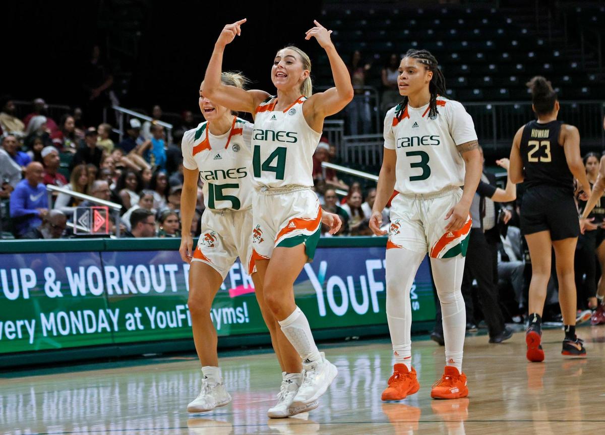 Miami Hurricanes guard Haley Cavinder (14) celebrates on the court with guard Hanna Cavinder (15) and forward Destiny Harden (3) as the Canes lead against the Florida State Seminoles in the fourth quarter at the Watsco Center in Coral Gables, Fl. on Thursday, February 9, 2023.