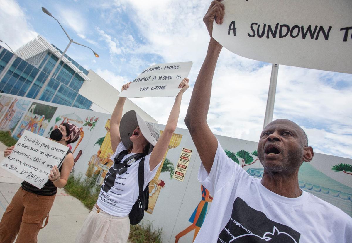 Kat Grimmett, Kat Duesterhaus and David Peery protest during a press conference about Operation Heat Relief on Monday, July 29, 2024 at Miami Beach City Hall.