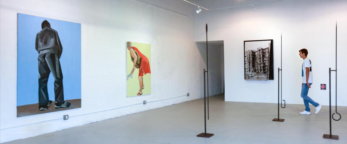 Max Voloshyn walks through the space he and his wife rented to hold their exhibition featuring Ukrainian artists on Monday, March 21, 2022. The show features paintings by Lesia Khomenko, which feature working class Ukrainians as giants.