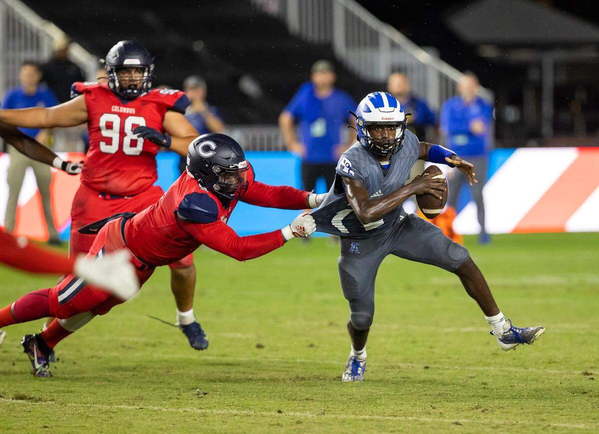 Columbus Explorers defensive end Daylen Russell (9) fails to tackle Apopka Blue Darters quarterback Tyson Davison (12) during the first quarter of their 2022 FHSAA State Championships-Class 4M football game on Saturday, Dec. 17, 2022, in Fort Lauderdale, Fla.