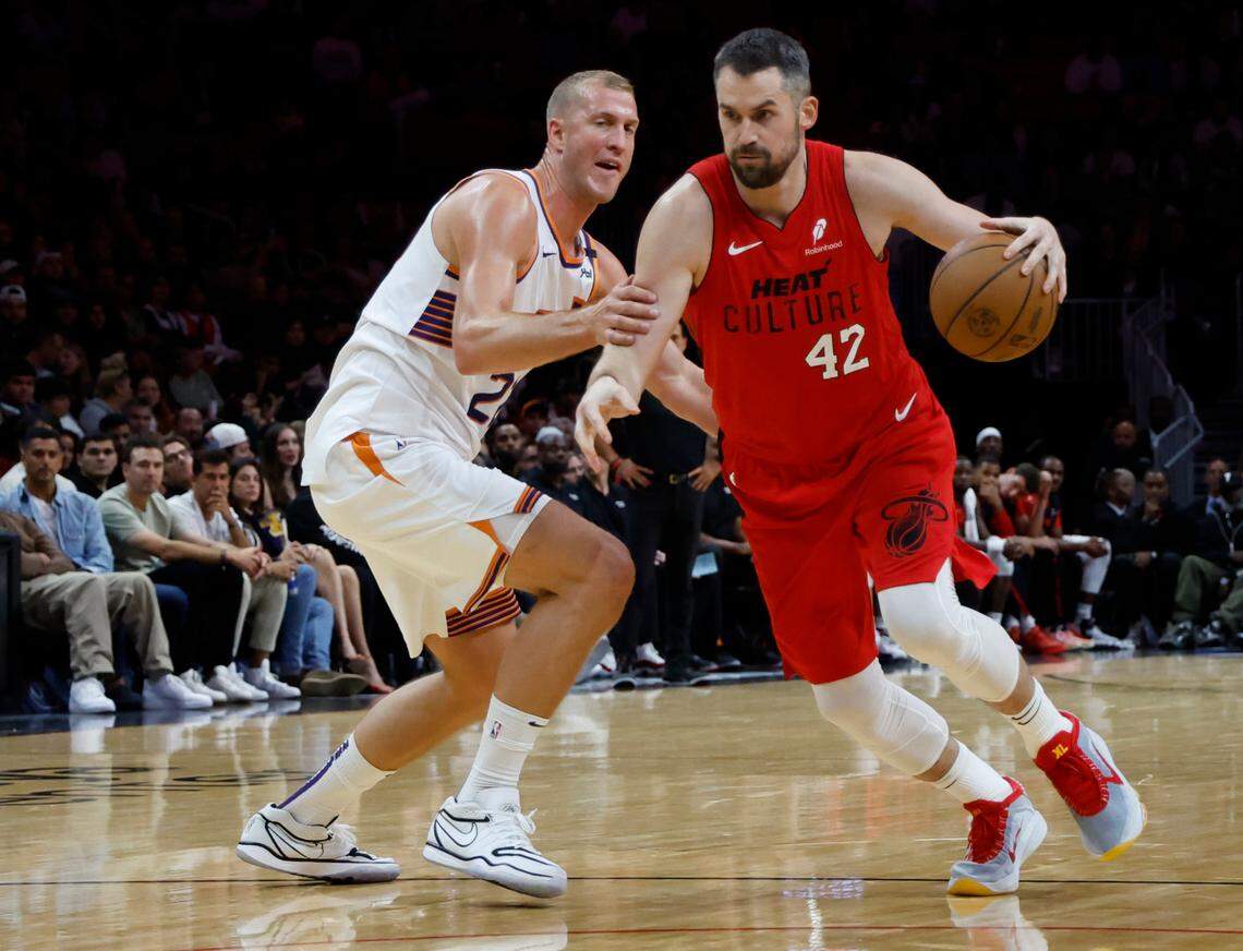 Miami Heat forward Kevin Love (42) drives to the basket as Phoenix Suns center Mason Plumlee (22) defends in the first half at Kaseya Center in Miami on December 7, 2024.