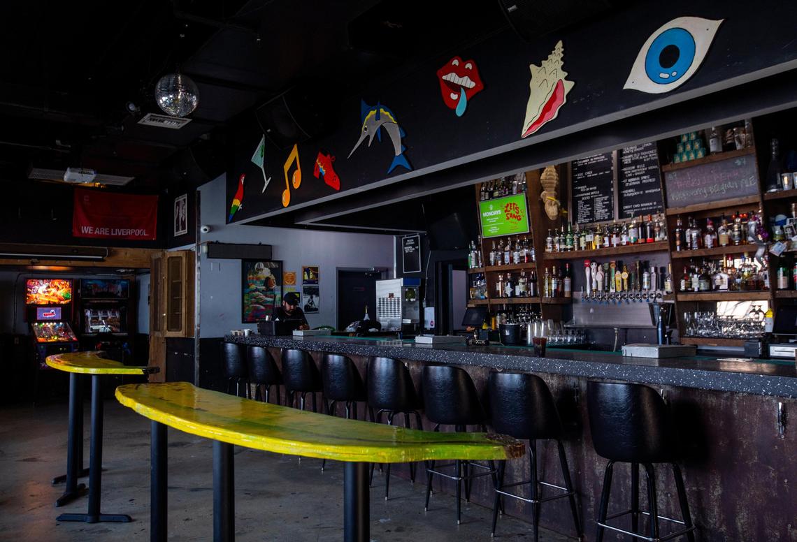 Gramps owner Adam Gersten works on his phone inside the closed bar in Miami, Florida, on Monday, March 16, 2020. Gramps closed its doors among growing concerns that the public wasn’t practicing social distancing.