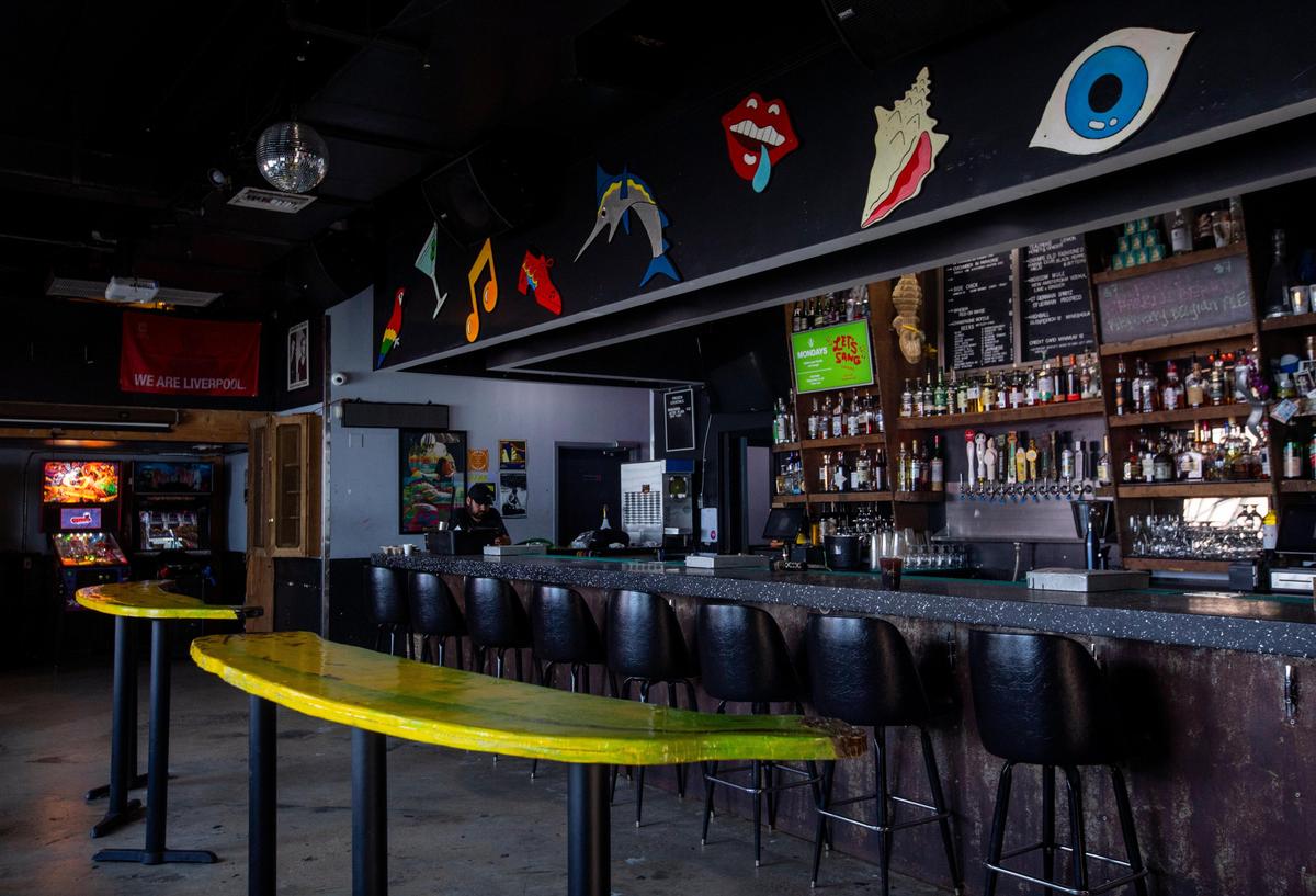 Gramps owner Adam Gersten works on his phone inside the closed bar in Miami, Florida, on Monday, March 16, 2020. Gramps closed its doors among growing concerns that the public wasn’t practicing social distancing.