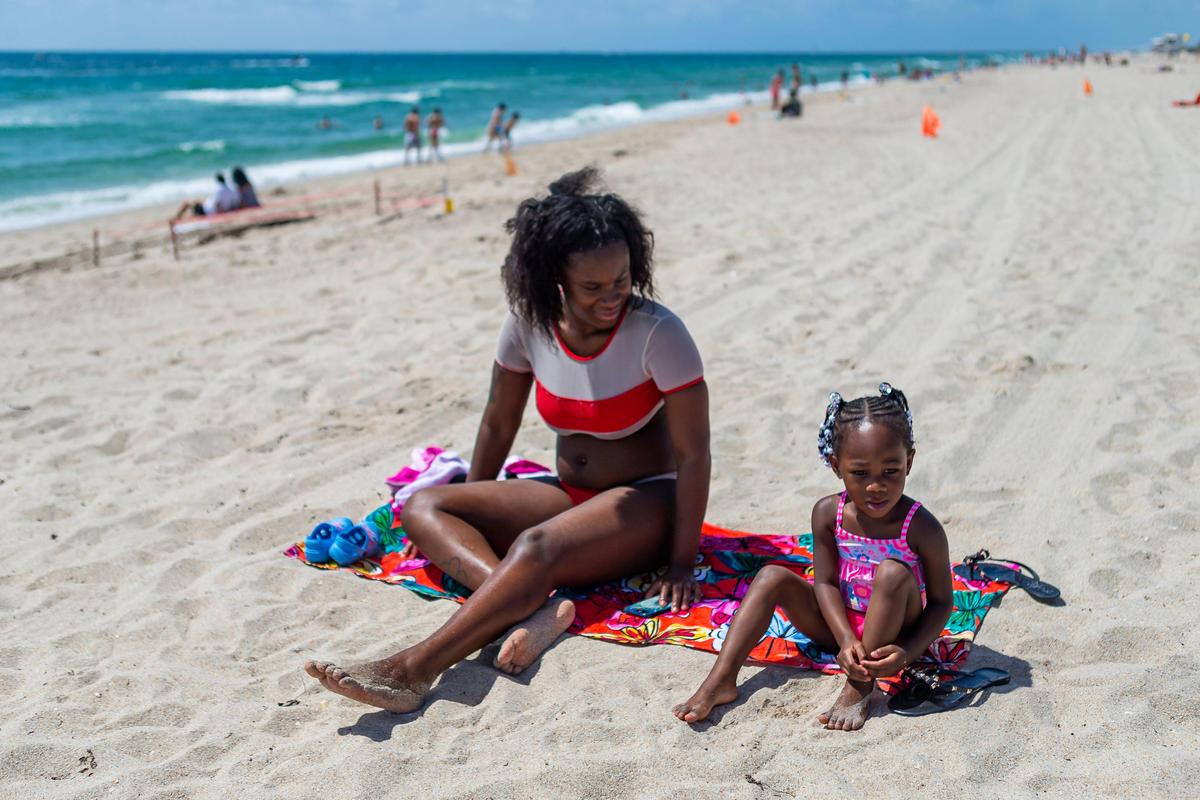 Lisa Richardson, 21, and her daughter, Kyvorie Richardson, 2, sunbathe at Las Olas Beach in Fort Lauderdale, Florida on Saturday, May 30, 2020.