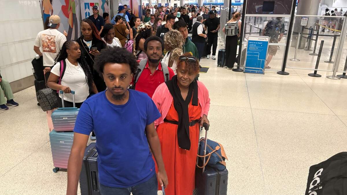 Michael Yonas, front, waits in an American Airlines rebooking line with his brother, Nebiya Yonas, and mother, Tayou