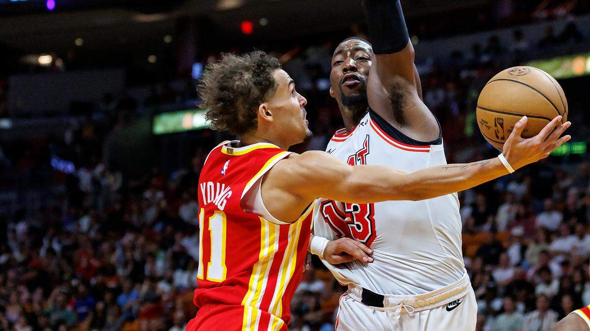 Atlanta Hawks guard Trae Young (11) goes to the basket against the defense of Miami Heat center Bam Adebayo (13) during the fourth quarter of an NBA game at the Miami-Dade Arena on Saturday, March 4, 2023, in Miami, Florida.