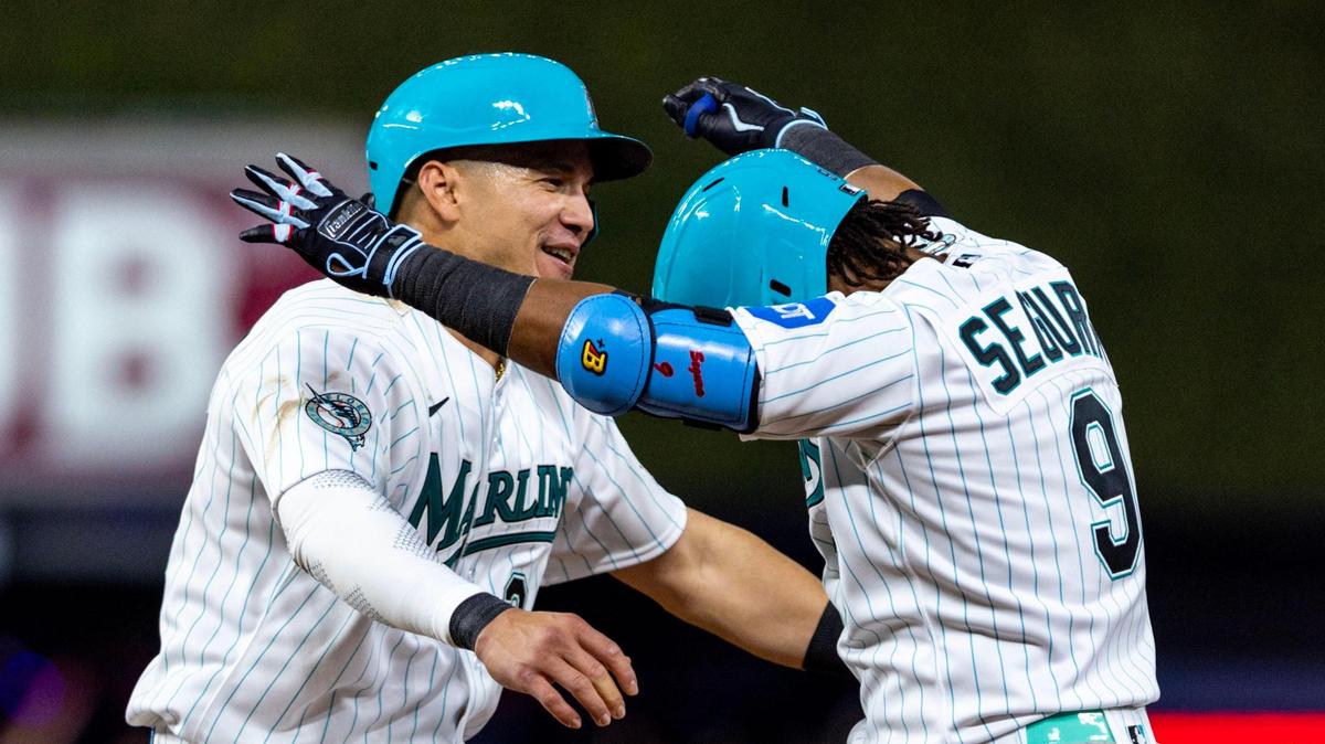 Miami Marlins batter Jean Segura (9) is embraced by teammate Avisail Garcia (24) after hitting a walk-off single during the ninth inning of an MLB game against the Chicago Cubs at loanDepot Park, in Miami, Florida, on Friday, April 28, 2023. The Marlins won 3-2 over the Cubs.