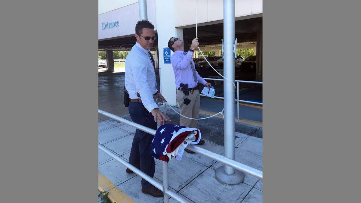 Monroe County Sheriff’s Office Detective Sgt. David Smith and Detective Spencer Curry raise the American flag outside the sheriff’s headquarters on Wednesday, March 6, 2019, after it was stolen on March 2.