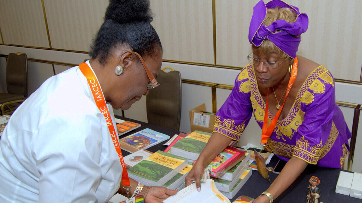 Katrenia Reeves-Jackman, director of the Office of Black Catholic Ministry for the Archdiocese of Miami, shows an African-American-themed Bible to a customer.