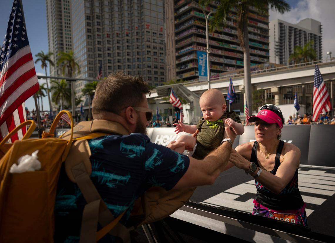 Solène George gets handed her baby to cross the finish line during the Life Time Miami Marathon and Half on Sunday, Jan. 28, 2024, finishing at Bayfront Park in downtown Miami.