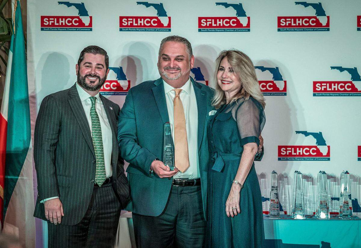Alex Mena, director ejecutivo del Miami Herald y El Nuevo Herald, muestra su Premio a la Excelencia en Comunicaciones otorgado por la Cámara de Comercio Hispana del Sur de la Florida (SFLHCC), acompañado por Alejandro Mendieta, secretario de la SFLHCC, y Liliam M. López, presidenta y directora ejecutiva de la organización, durante el almuerzo de los Premios al Liderazgo Hispano en el Hotel Biltmore de Coral Gables, el viernes 14 de marzo de 2025.
