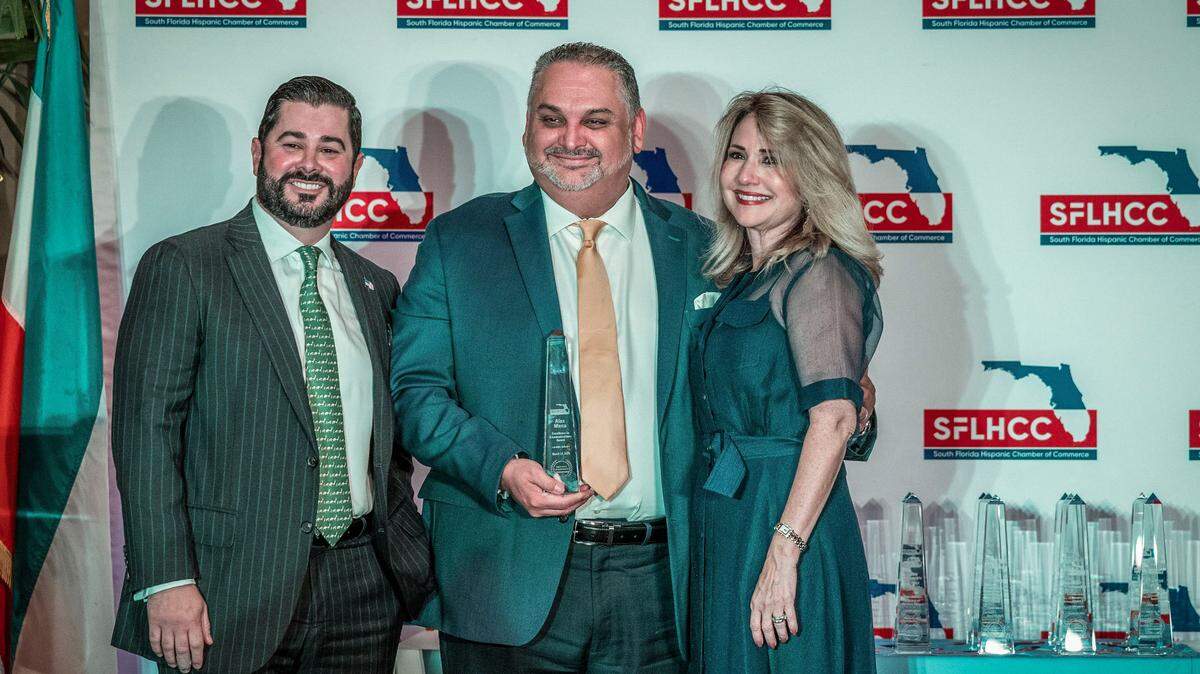 Alex Mena, Miami Herald-El Nuevo Herald Executive Editor, displays his SFLHCC Excellence in Communications Award flanked by Alejandro Mendieta, SFLHCC Secretary and Liliam M. Lopez, President/CEO SFLHCC, during the South Florida Hispanic Chamber of Commerce’s ‘Hispanic Leadership Awards” lunch at the Biltmore Hotel in Coral Gables, on Friday March 14, 2025.