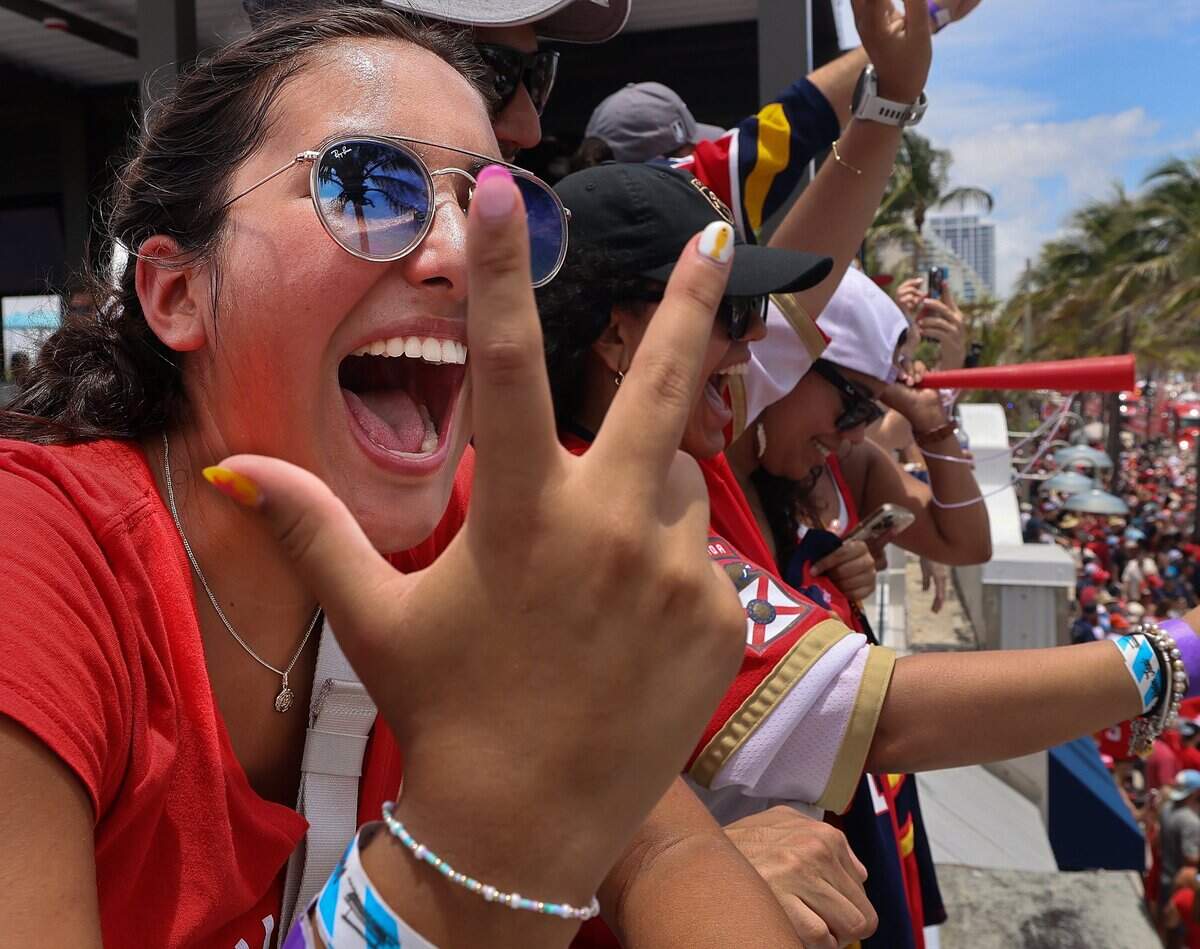 Panthers fan Lorelai Gomez, 17, from Palm City, signs “three peat” as she cheers on the Panthers on A1A just north of the staging area for the Florida Panthers Stanley Cup championship celebration parade on Sunday, June 22, 2025 in Fort Lauderdale, Florida.