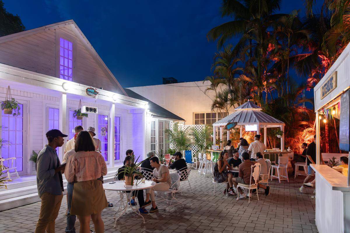 The bungalow at left houses DJs and a vinyl listening room at ZeyZey. Guests can buy natural wine or craft beer at the gazebo.
