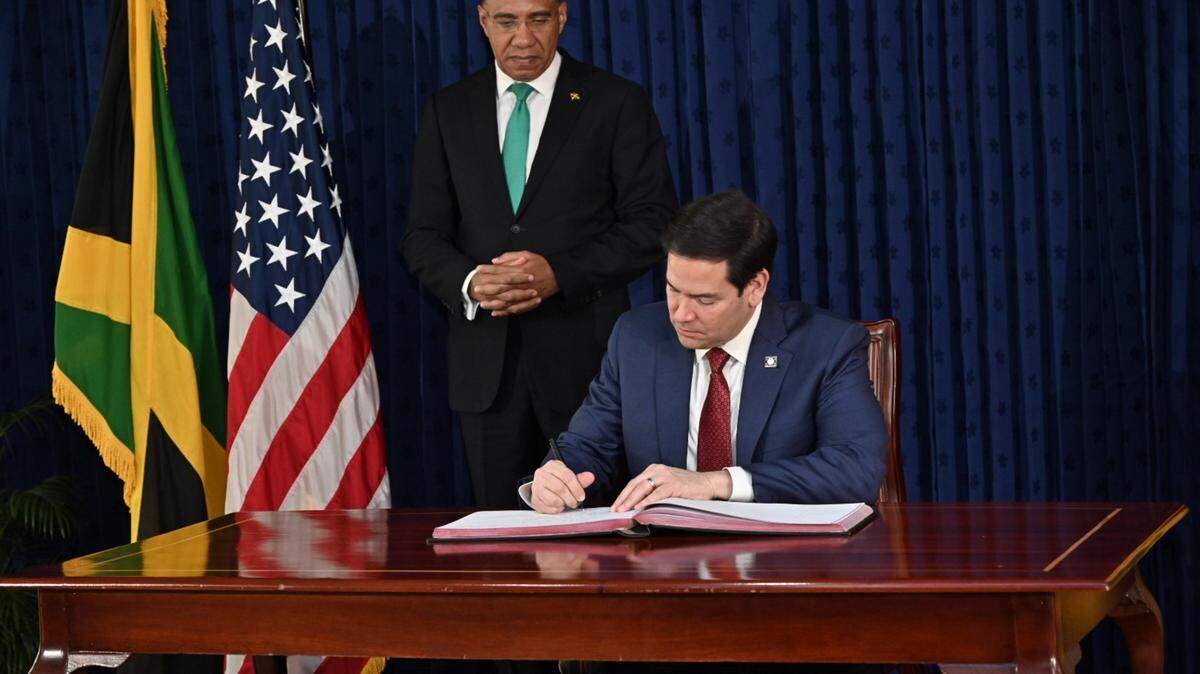 U.S. Secretary of State Marco Rubio (r) signs the guestbook with Jamaican Prime Minister Andrew Holness at Jamaica House in Kingston, Jamaica, on Wednesday, March 26, 2025. 