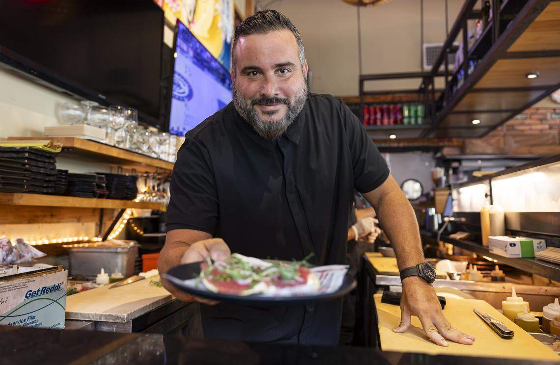 Chef Jose Mendin serves a Tuna Pizza at his restaurant, Pubbelly Sushi, on Thursday, Sept. 18, 2025, in Miami Beach, Fla. Mendin, who is Puerto Rican, is celebrating the restaurant's 15th anniversary. The appetizer consists of crispy tortilla, garlic aioli and truffle oil.