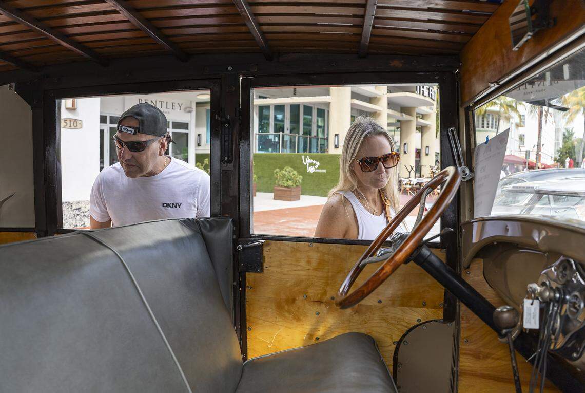 Javier Rodriguez and Alina Galiano look inside a 1929 Ford Model A Woody on display at the Classic Car Show during Art Deco Weekend at Ocean Drive on Saturday, Jan. 10, 2026, in Miami Beach, Fla.