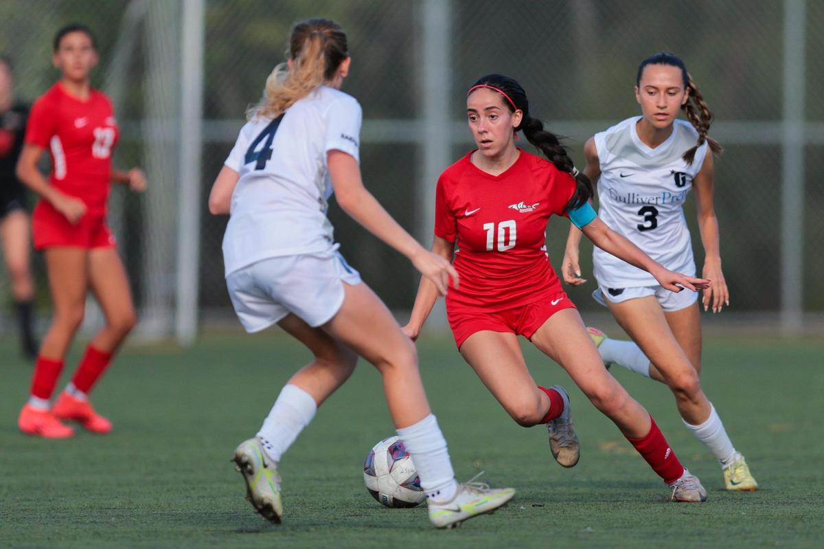 MAST Academy midfielder Claudia Alonzo (10) dribbles the ball past Gulliver Prep midfielder Kaira Krippendorff (3) during the first half of a girls soccer playoff game at MAST Academy in Miami, Florida, Tuesday, February 11, 2025.