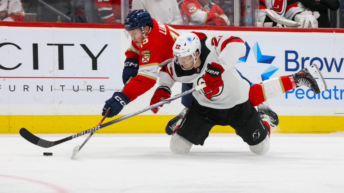 Florida Panthers center Anton Lundell (15) dives over New Jersey Devils defenseman Brett Pesce (22) during the third period of a game on Tuesday, Nov. 12, 2024, at Amerant Bank Arena in Sunrise, Fla. The Devils won 4-1.