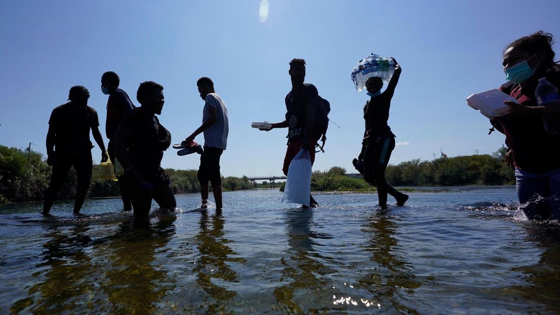 Haitian migrants use a dam to cross to and from the United States from Mexico, Friday, Sept. 17, 2021, in Del Rio, Texas.