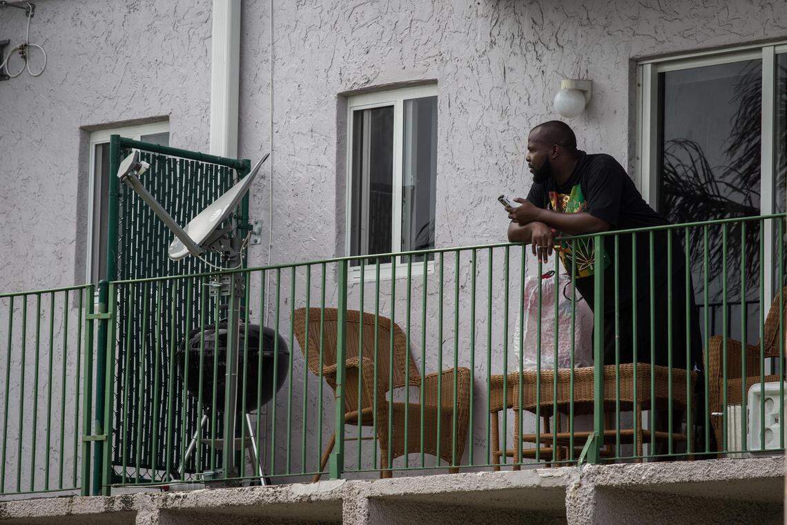 Residents from Glorieta Gardens apartments watch the crime scene after a police officer shot a robbery suspect in Opa-locka on Wednesday, May 23, 2018.