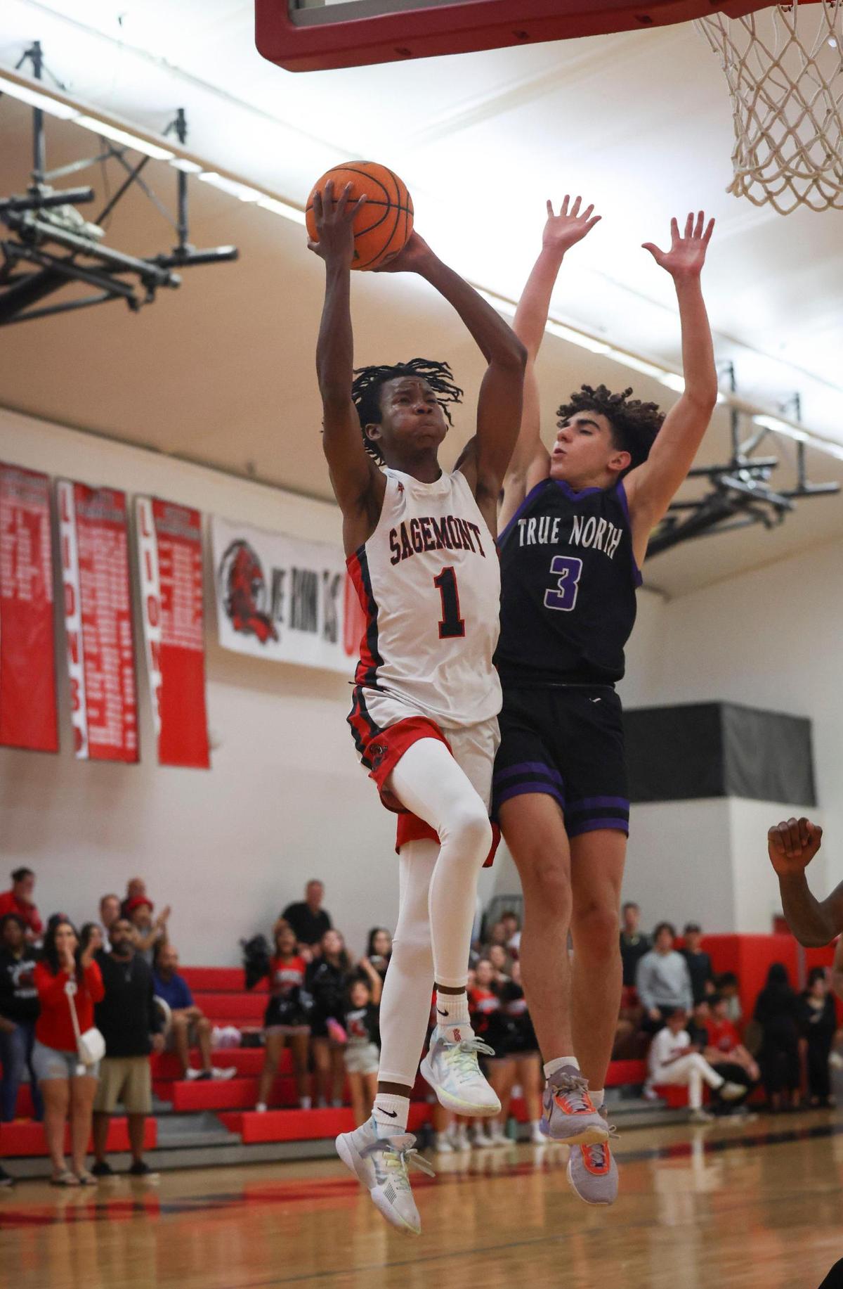 Sagemont’s Ashton Smith (1) shoots a layup while being guarded by True North’s J Roc Lopez (3) during the second quarter of the regional semifinal playoff game between the Sagemont Prep Lions and the True North Titans on Tuesday, Feb. 21, 2023, at Sagemont High School.