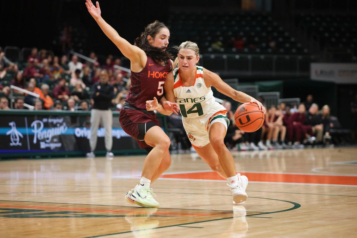 Hurricane’s Haley Cavinder (14) drives the ball around Virginia Tech’s Georgia Amoore (5) during the third quarter of the NCAA game between the University of Miami Hurricanes and Virginia Tech on Sunday, Jan. 8, 2023, at Watsco Center in Coral Gables. The Hurricanes won 77-66.