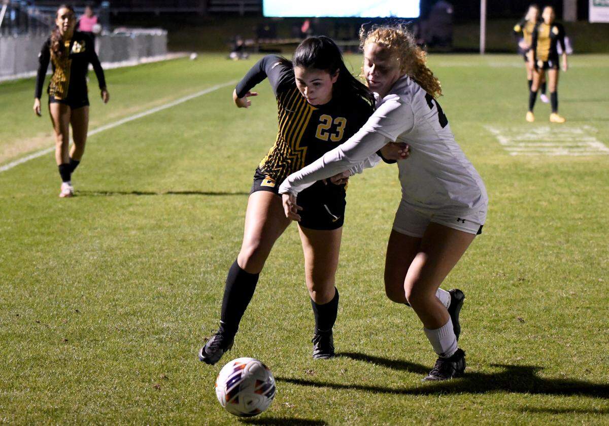 American Heritage senior forward Samantha Villaverde (23) battles with an Orlando Bishop Moore defender during the Class 4A girls soccer state championship game on Friday at Lake Myrtle Sports Complex.