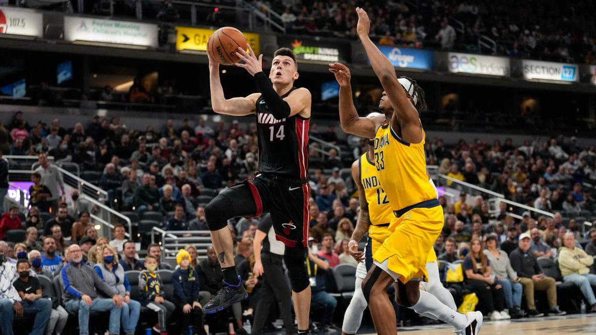 Miami Heat guard Tyler Herro (14) shoots in front of Indiana Pacers center Myles Turner during the first half of an NBA basketball game in Indianapolis, Friday, Dec. 3, 2021.