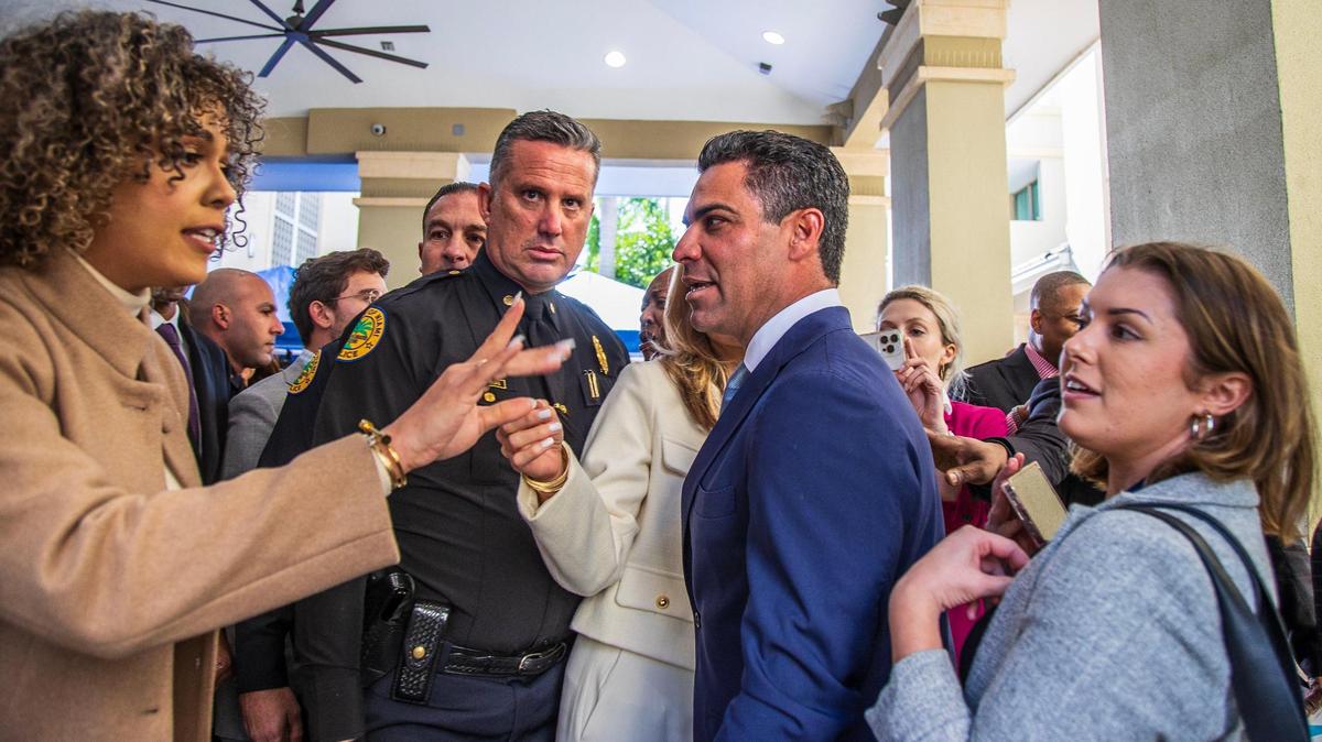 Stephanie Severino, a la izquierda, directora de comunicaciones del alcalde de Miami, Francis Suárez, en el centro a la derecha, protege al alcalde de la reportera del Herald Tess Riski, a la derecha, tras su discurso sobre el Estado de la Ciudad, el martes 30 de enero en Camillus House.
