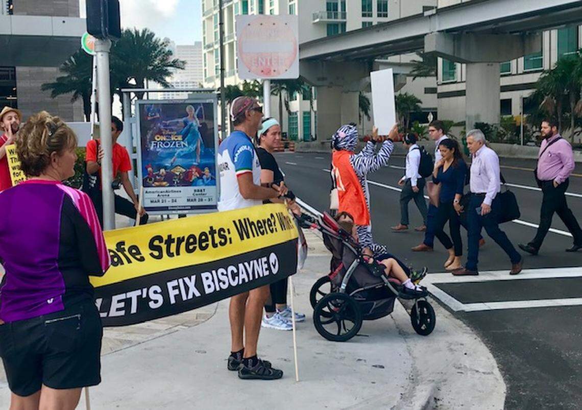 Protesters and pedestrians at a busy Biscayne Boulevard intersection outside the Safe Streets Summit conference.