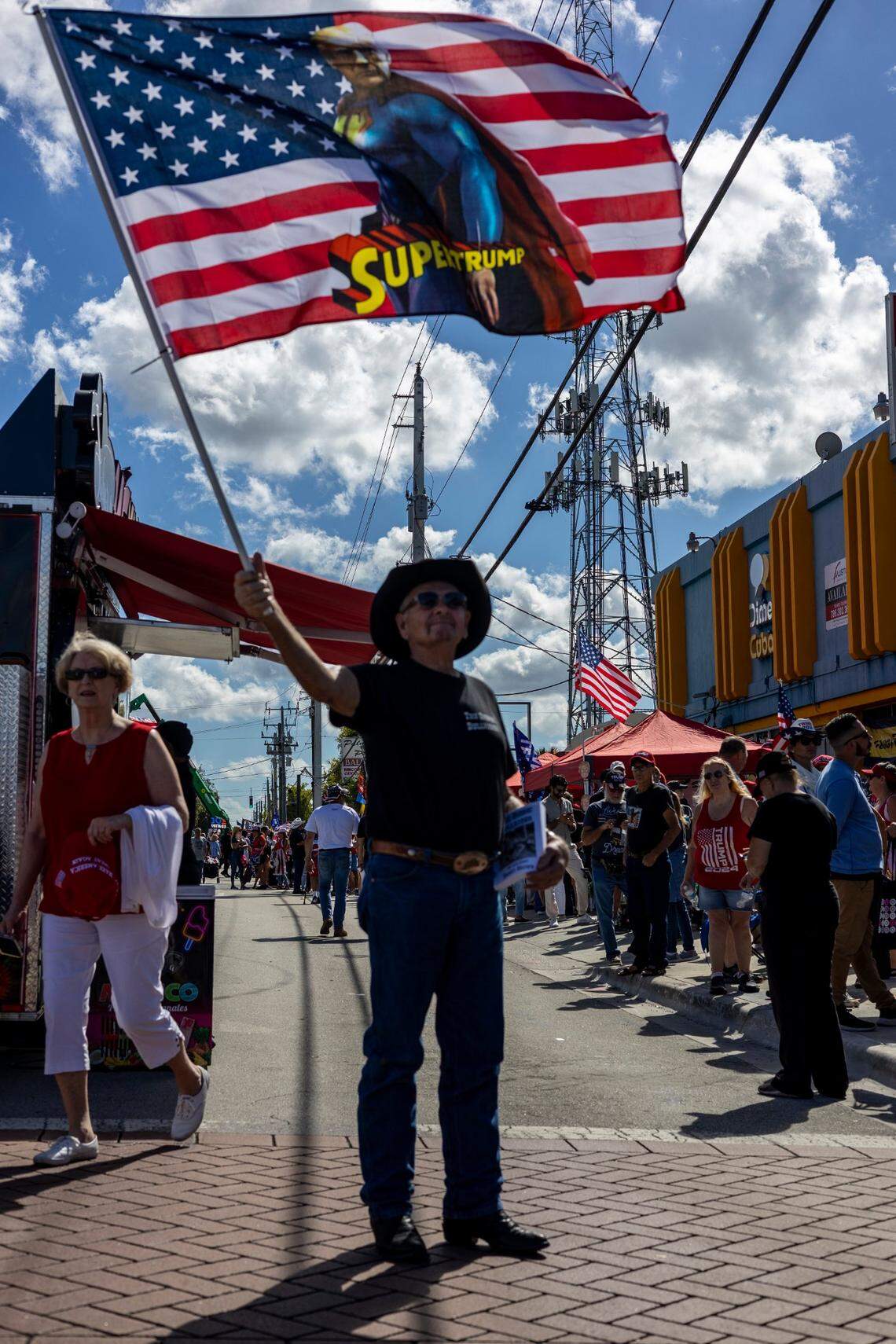 A Trump supporter waves a flag while in line to get into Ted Hendricks Stadium for the rally later this evening.