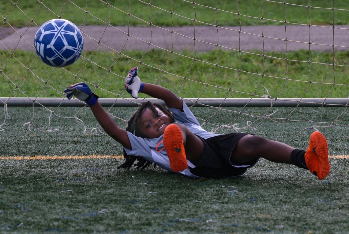 Maekinson Desir lands on his back while trying to stop a goal during practice at the Little Haiti Soccer Park in Miami, Florida.