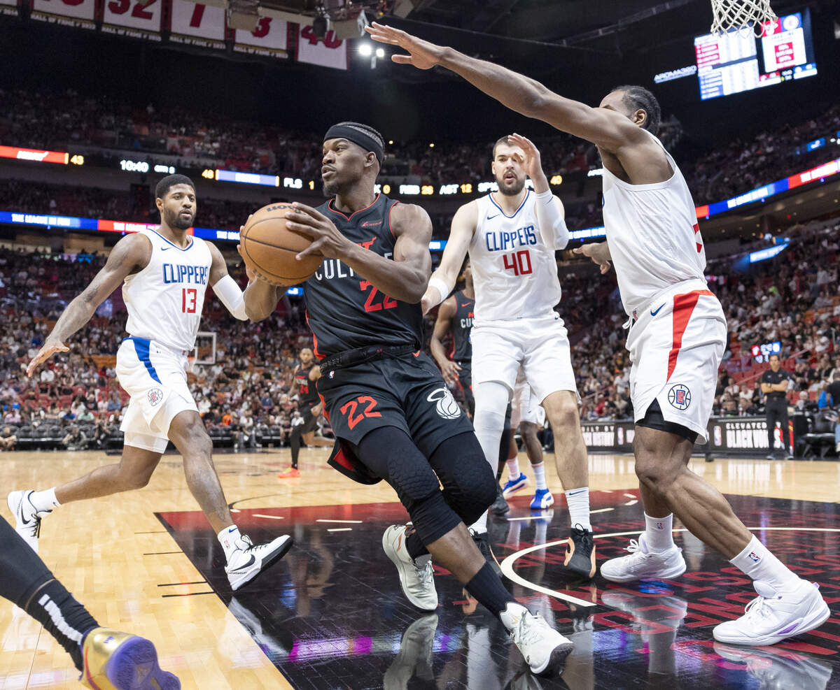 El delantero del Heat Jimmy Butler (22) busca pasar el balón ante la marca de Kawhi Leonard (der.), Paul George (izq.) y el centro Ivica Zubac, de los Clippers de Los Angeles,  en el tercer cuarto del partido celebrado el 4 de febrero de 2024 en Miami.