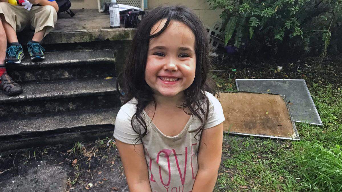 Mesha Farland, 4, is credited with saving her family from a fire in their Jacksonville home, seen in the background, when she alerted her parents to the flames on Aug. 30, 2018.