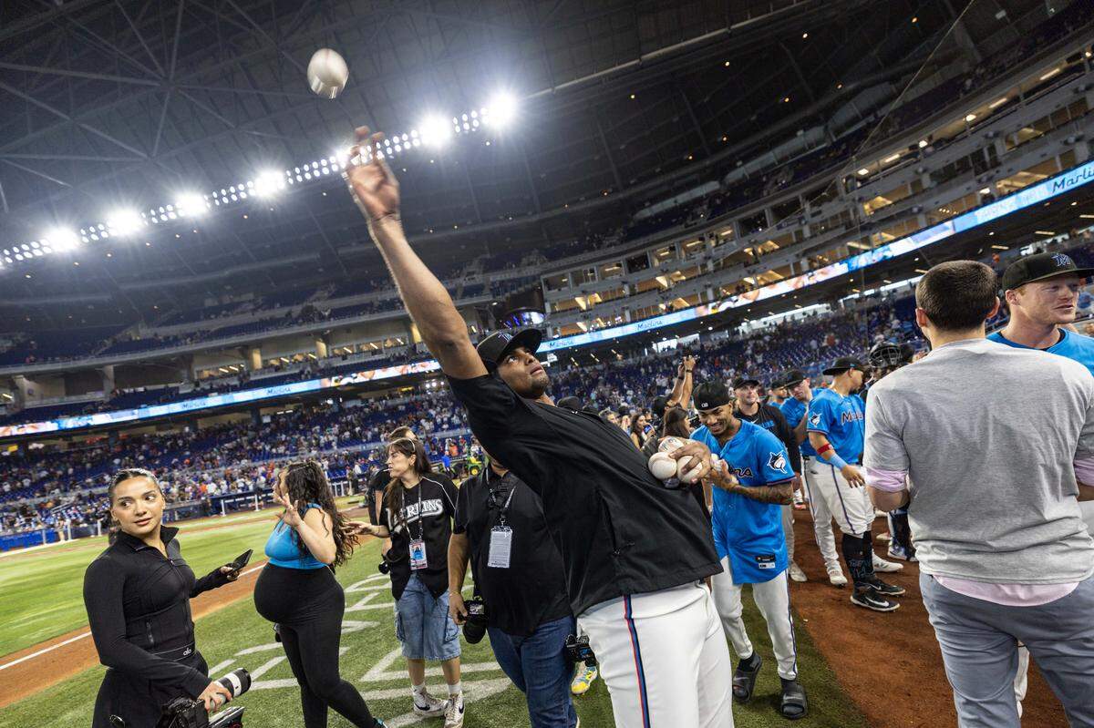 Pitcher Edward Cabrera (27) tosses balls in to the stands as the Miami Marlins team celebrates defeating the New York Mets 4-0 after the last regular season MLB game at loanDepot park on Sunday, September 29, 2025, in Miami, Fla.