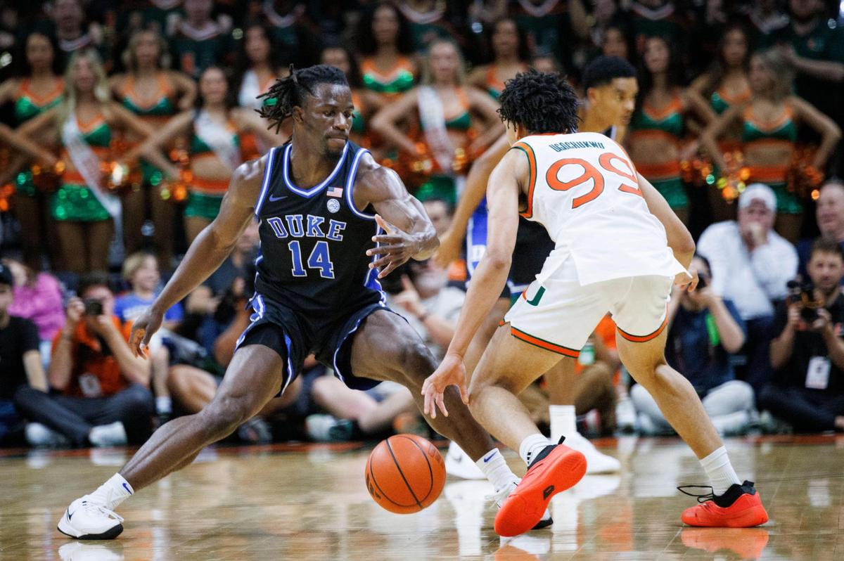 Duke Blue Devils guard Sion James (14) defends Miami (Fl) Hurricanes guard Divine Ugochukwu (99) during the first half of a game on Tuesday, Feb. 25, 2025, at Watsco Center in Coral Gables, Fla.