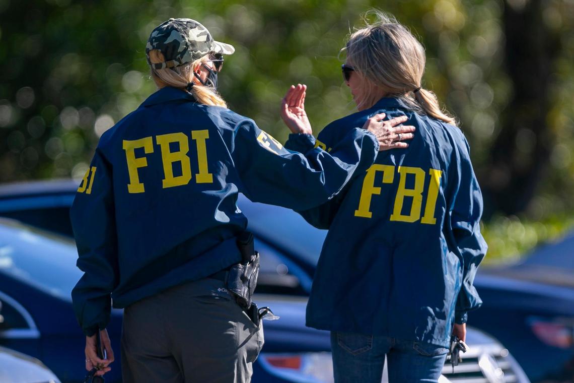 An FBI agent is consoled near the Broward County Office of Medical Examiner and Trauma Services in Fort Lauderdale, Florida on Tuesday, February 2, 2021. Two FBI agents were shot and killed and others injured while serving a warrant at a Sunrise home near Nob Hill Road and Northwest 44th Street.