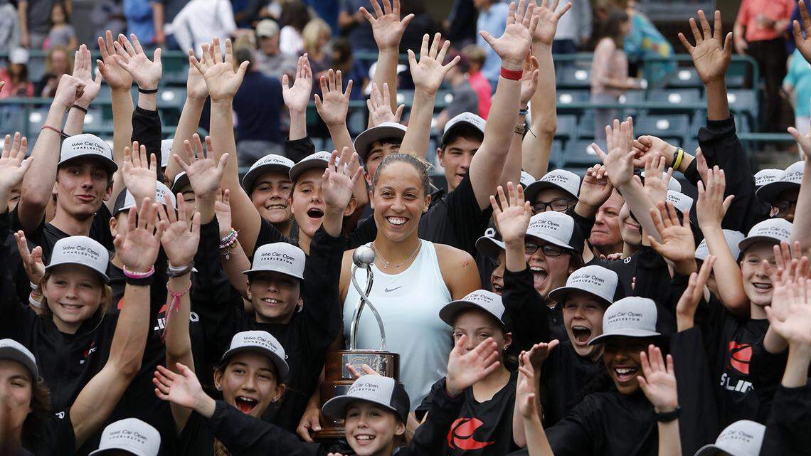 Madison Keys, center, celebrates with the ball boys and ball girls after defeating Caroline Wozniacki, from Denmark, to win their finals match at the Volvo Car Open tennis tournament in Charleston, S.C., Sunday, April 7, 2019.