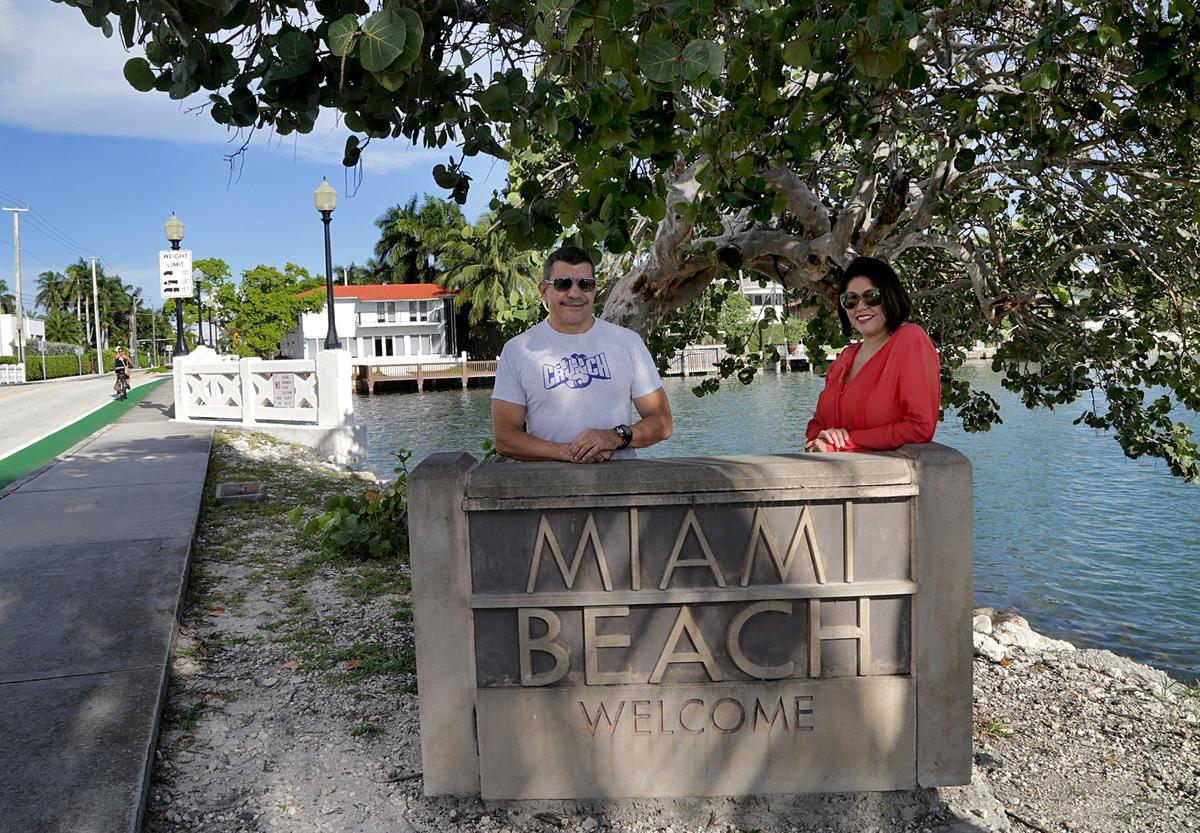 Biscayne Island residents Diana Fontani and Mario Reyes stand by the Welcome to Miami Beach sign that marks the limits between Miami Beach and Miami. Their island is located in Miami, but they’re circulating a petition to join Miami Beach.