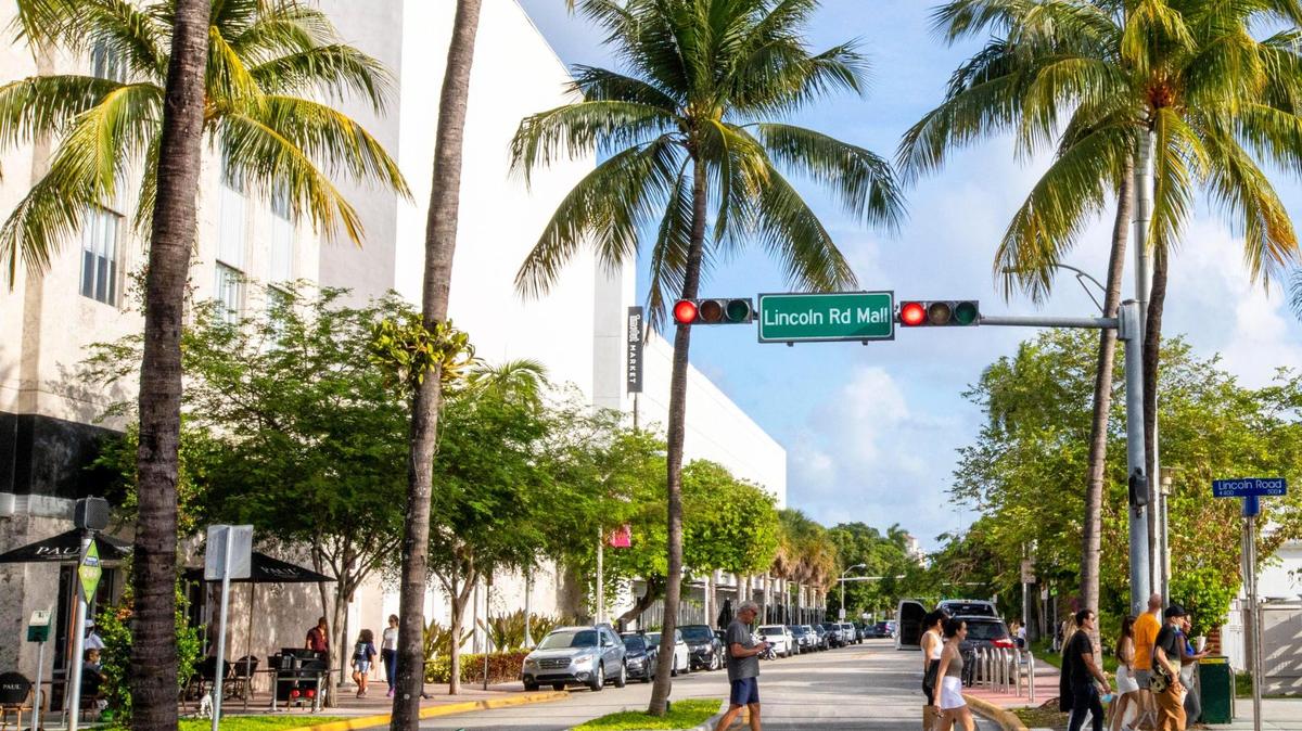 People cross the street at Lincoln Road and Drexel Avenue in Miami Beach, Florida, on Monday, June 7, 2021.